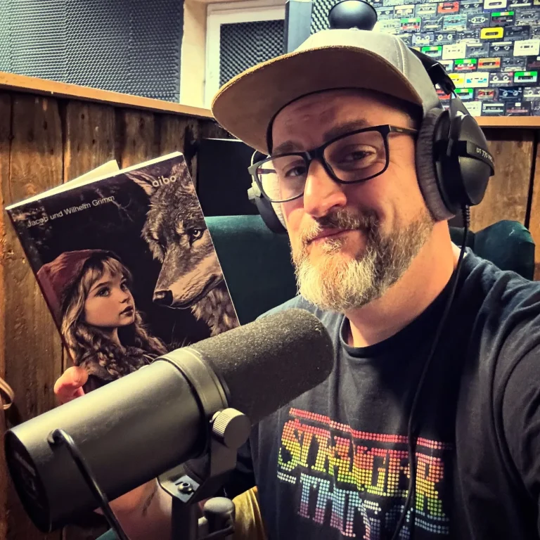 Markus Grimm mit dem Buch Deutsche Märchen in seinem Studio beim Einsprechen.